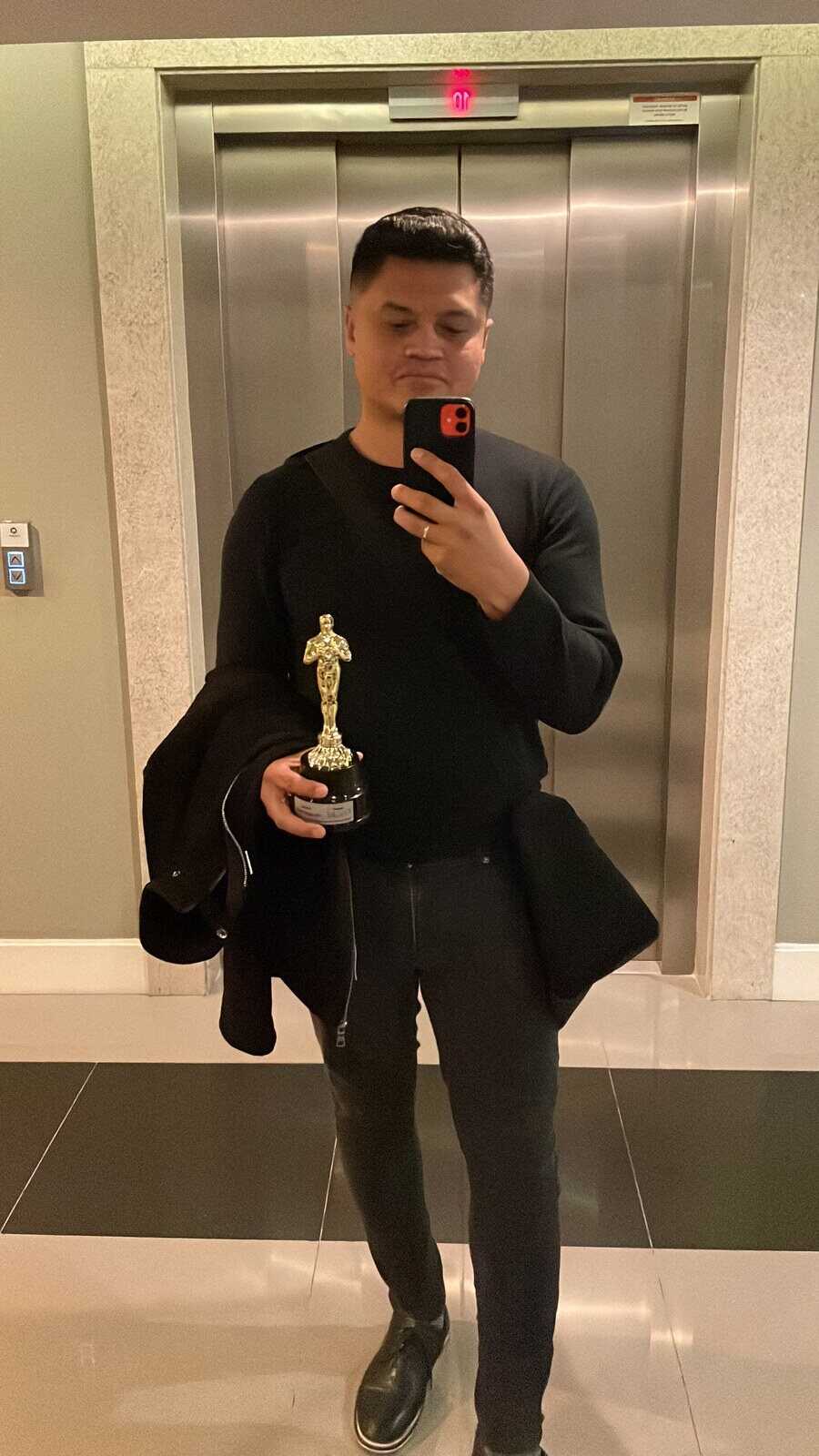 Tiago segurando o troféu de Diretor Campeão após sua trajetória na imobiliária.